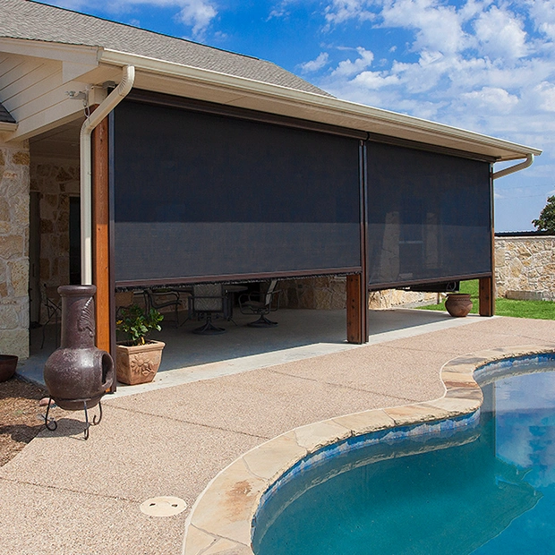 Retractable screen surrounding a covered home patio next to a pool