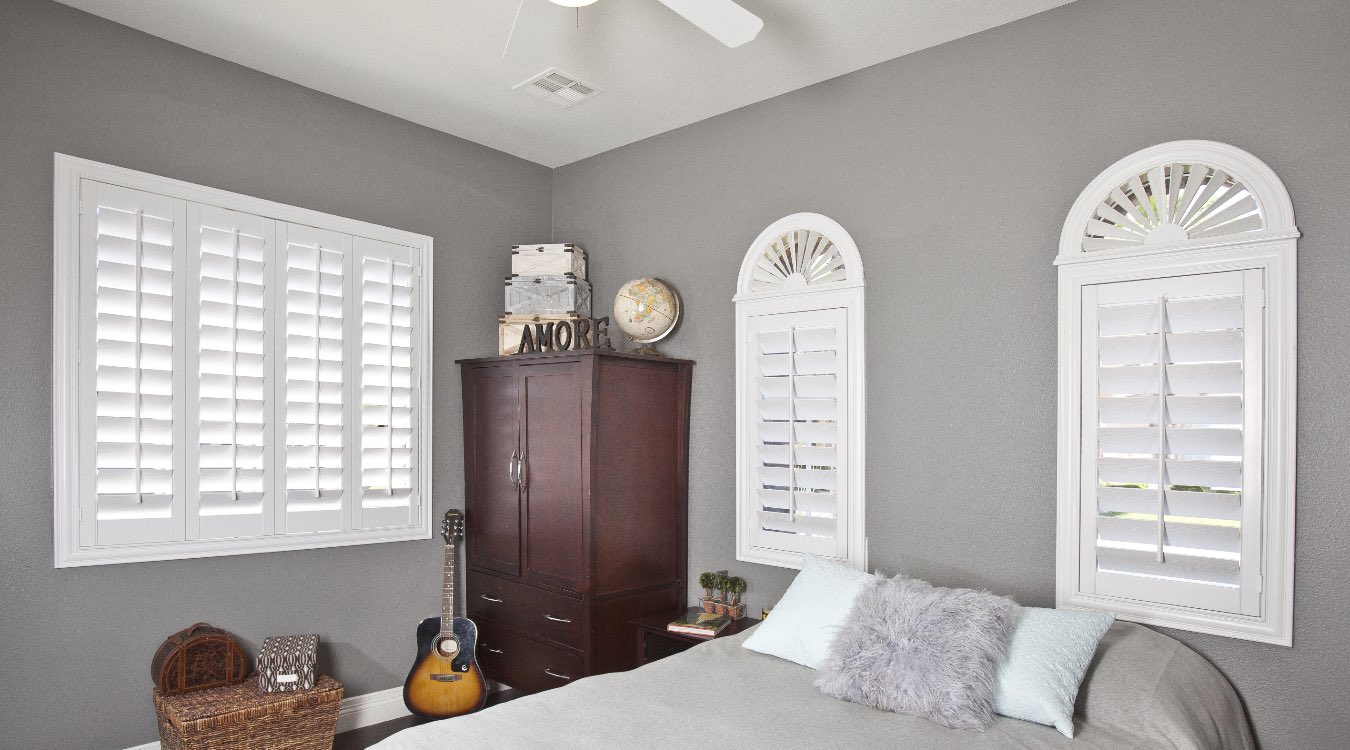 Arched white shutters in bedroom