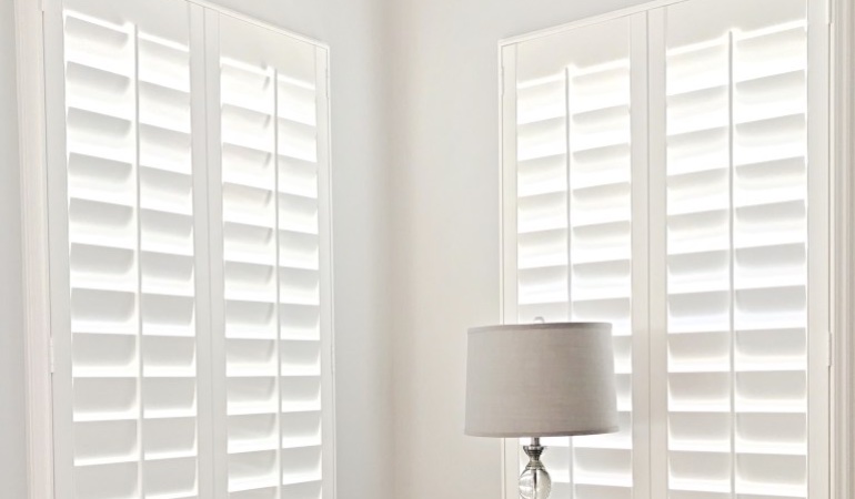 Plantation shutters can be found in a wide array of neutral whites and wood stains. Plantation shutters in a corner window.