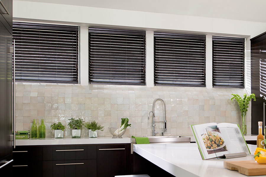 Choose custom Polywood faux wood blinds for your kitchen in Dallas. Special shaped faux wood blinds in several windows above a sink.
