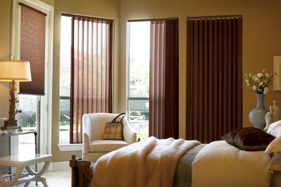 Choose durable and high-quality fabric or vinyl vertical blinds in Dallas. Maroon fabric vertical blinds inside a bedroom