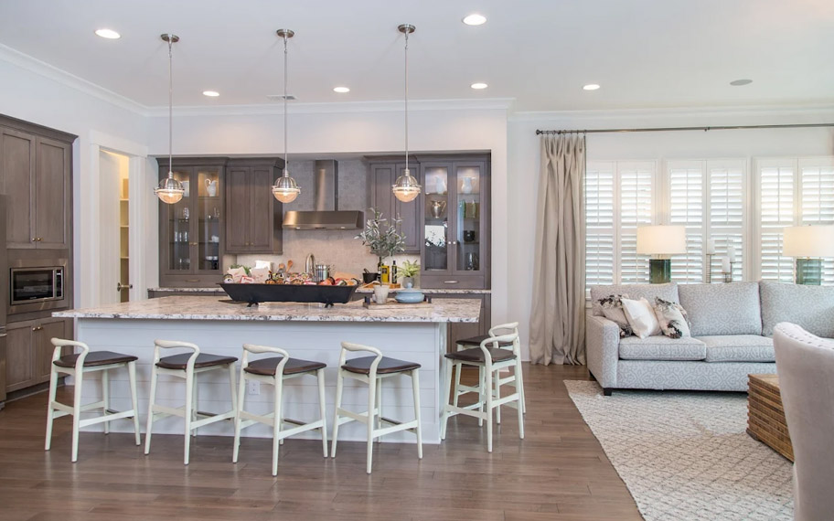 Illuminate your home with custom interior shutters in Dallas. White arched shutters in a white kitchen with lots of light.