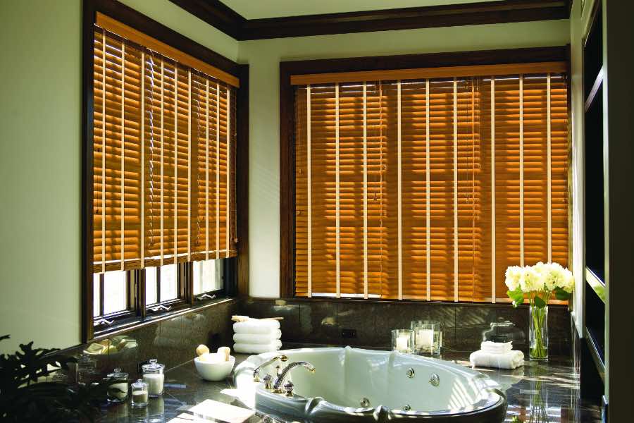 Premium quality blinds are always a stylish accent in your Dallas home. Brown wood blinds on large windows in a green bathroom