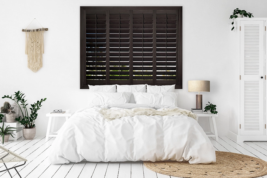  Dark wood Ovation shutters on a window in a white bedroom