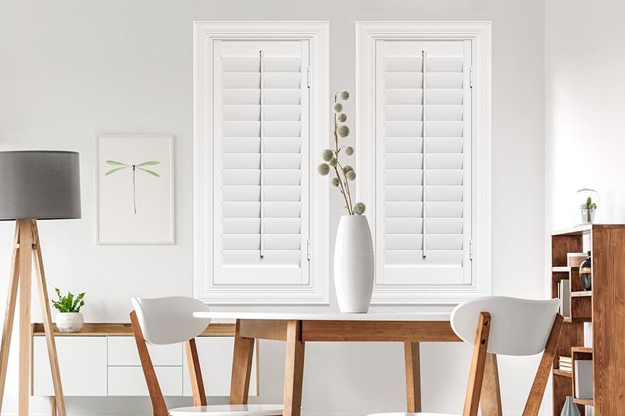 Sunburst's selection of stylish window treatments for designers in Dallas makes it easy to find the perfect ones for every design job.  White Polywood shutters on two windows in a modern Scandinavian-style room